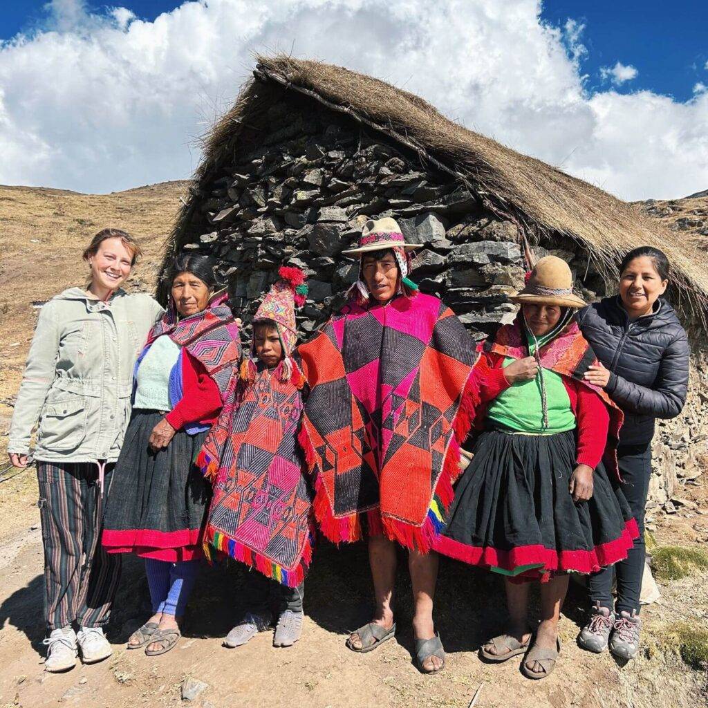 shaman family in front of stone house