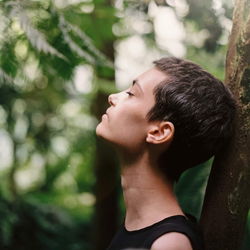 woman leaning on tree